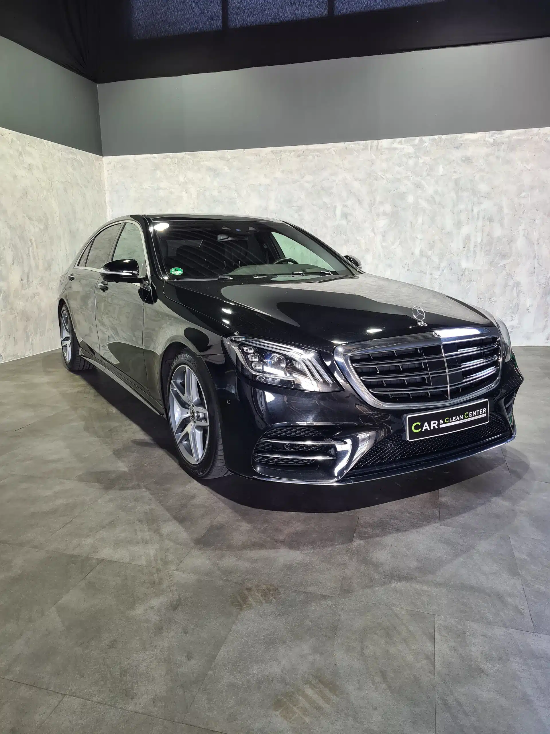 Schwarze Mercedes-Limousine nach professioneller Fahrzeugaufbereitung im Präsentationsbereich des Car & Clean Centers.