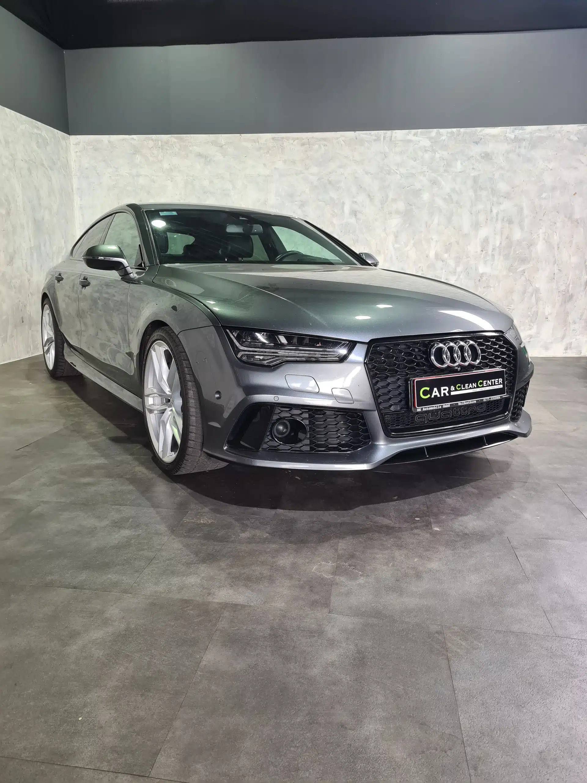 Grauer Audi RS7 schräg von vorne fotografiert, in heller Fotobox.