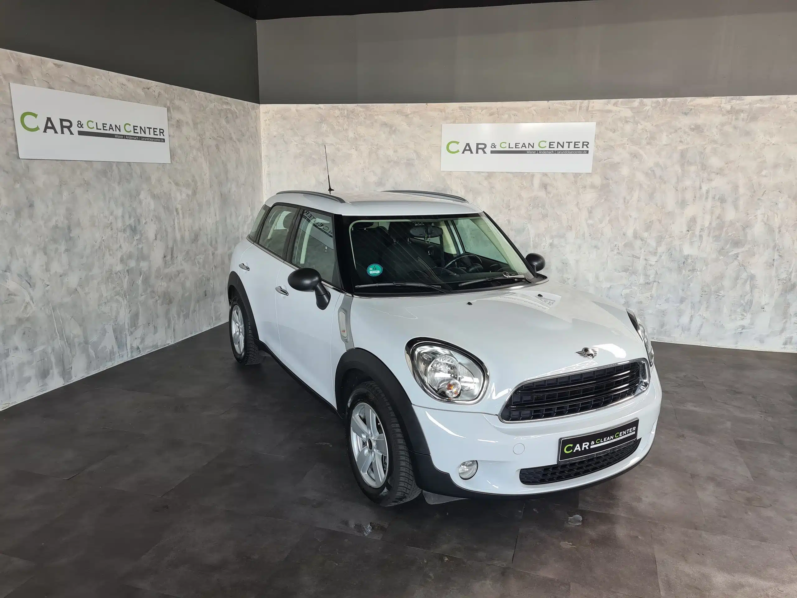 Weißer Mini Cooper im Car & Clean Center nach der Fahrzeugaufbereitung.