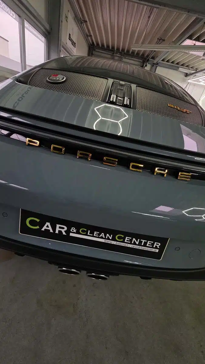 Heckansicht eines Porsche nach professioneller Aufbereitung, mit glänzendem Lack und reflektierender LED-Hexagon-Beleuchtung.